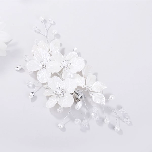 Close-up of bridal hair clip with white shell flowers, pearls and crystals on silver wire