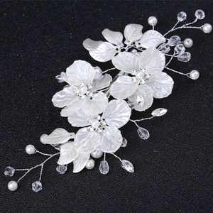 Detail of white shell flowers and pearls on bridal hair clip with silver wire