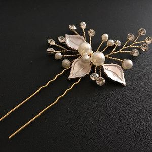Detail of handmade pearl hair pin with silver leaves and rhinestones on black background