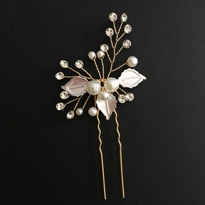 Detail of handmade bridal hair pin with white leaves, pearls and crystals on gold wire