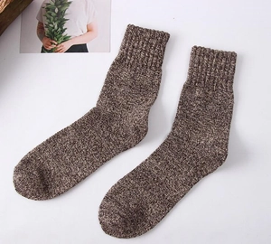 Detailed view of thick winter knit wool blend crew socks in brown marl texture closeup.