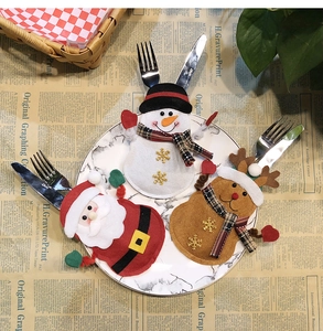 Detail of Christmas cutlery holders featuring Santa, Snowman, and Reindeer on a plate