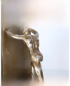 Detail of matte gold athlete sculpture showing realistic muscle textures and fine metal craftsmanship