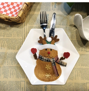 Detail of reindeer cutlery holder with gold snowflake embroidery on a holiday table