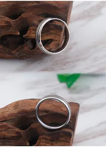 Detailed views of a polished silver titanium ring featuring a sleek center groove design