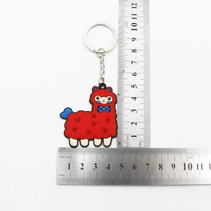 Red PVC alpaca keychain with blue bowtie and metal ring on white background