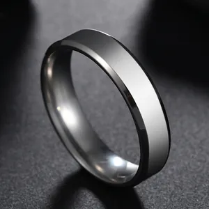 Polished 6mm stainless steel flat band ring with bevelled edges on a dark texture