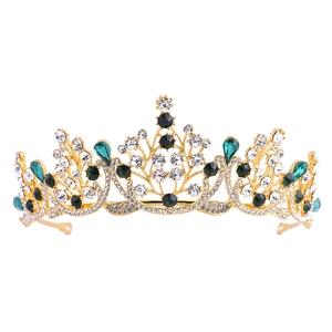 Détail d'un diadème doré de mariage avec cristaux vert émeraude et strass blancs brillants