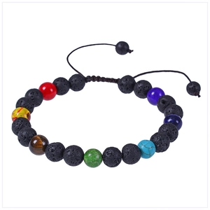 Détail d'un bracelet chakra en pierre de lave réglable avec texture poreuse et sept perles