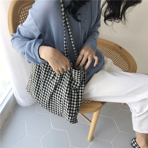 Girl wearing black and white checkered canvas tote bag in a casual lifestyle setting