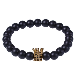 Natural lava stone beaded bracelet with a micro-paved gold crown charm on white background