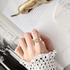 Close-up of a vintage 925 silver gold ring featuring an engraved heart and sunburst pattern