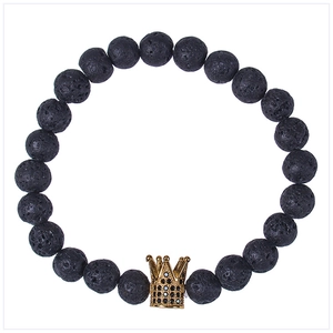 Macro shot of lava stone beads and gold-toned crown charm with black zircons