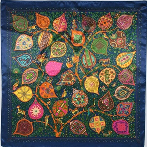 Flat lay of silk-satin scarf with vibrant saddle pattern and deep blue borders