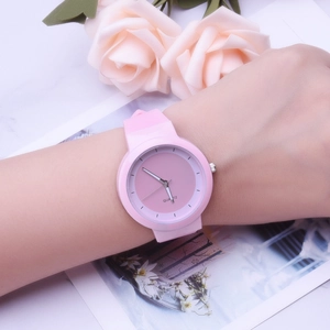 Close-up of pink silicone jelly quartz watch on wrist with elegant floral background
