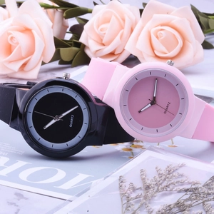 Close-up of pink and black minimalist silicone quartz watches with floral background