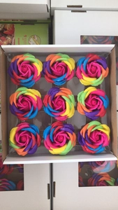 Macro shot of nine gradient rainbow rose soap flowers arranged in a white gift box