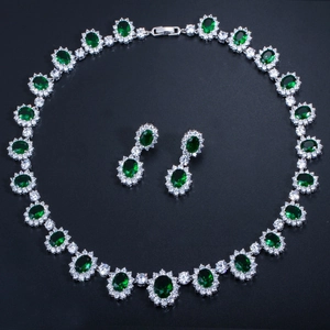 Vue macro d'une parure de bijoux avec pierres vert émeraude et zircons cubiques AAA