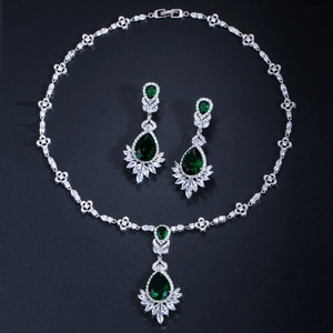 Detailed view of silver bridal jewelry set with emerald stones and zircon accents