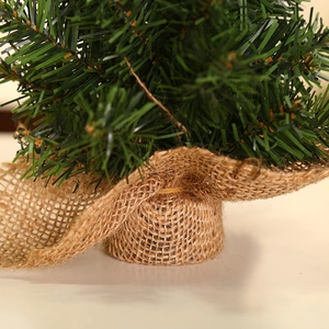 Mini green Christmas tree with rustic burlap base for tabletop holiday decoration