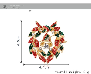 Detailed view of Christmas wreath brooch with colorful rhinestones and gold bell