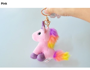 Detailed shot of pink plush unicorn keychain with rainbow mane and gold metal lobster clasp