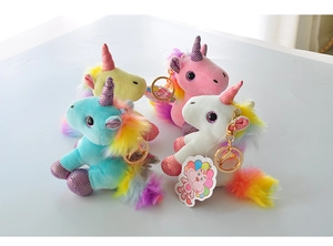 Close-up of four colorful plush unicorn keychains with rainbow manes and sequin details