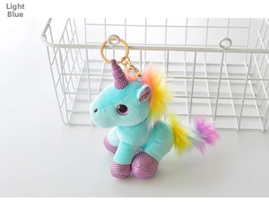 Detail of light blue unicorn plush pendant with rainbow mane and golden metal clip