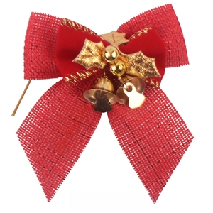 Detail of red linen and velvet Christmas bow with gold bells and leaves for decor