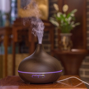 Detail of essential oil diffuser with dark wood grain finish and mist settings