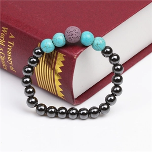 Detail of beaded bracelet with black magnetic stone and turquoise on a vintage book