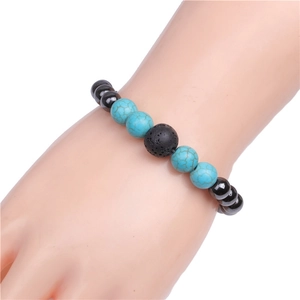 Detail of beaded bracelet with blue turquoise, black lava stone, and grey beads on wrist