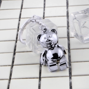 Silver metallic teddy bear keychain with polished finish on a minimalist white background