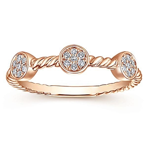 Detailed close-up of rose gold twisted band ring with three clustered zircon settings