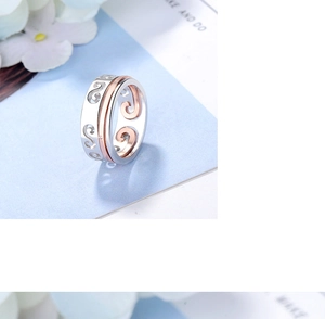 Detail shot of dual-tone silver and rose gold ring featuring intricate hollow cloud patterns