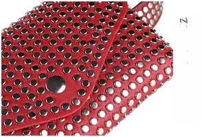 Détail macro du sac en cuir rouge avec rivets métalliques argentés punk et fermoir pression