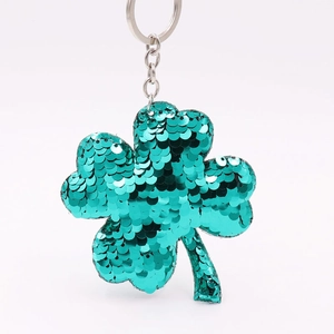 Close-up of green sequin clover keychain with reflective finish and silver metal ring
