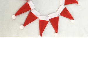 Close-up of mini red and white Christmas hat cutlery holders for festive table decor