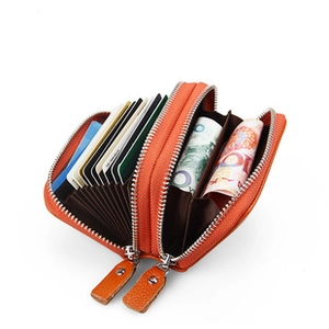 Detail view of orange leather accordion card wallet with dual zippers and slots