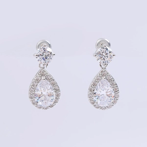 Detailed macro view of silver drop earrings featuring clear pear-shaped cubic zirconia stones