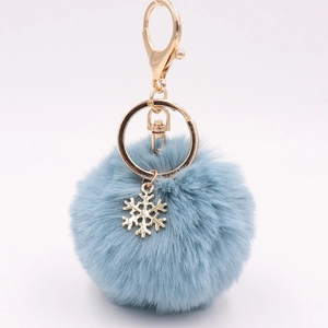 Detailed close-up of light blue plush ball keychain with golden snowflake charm and alloy hook