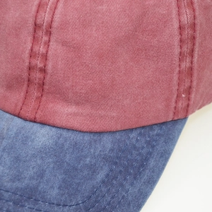 Macro shot of washed cotton baseball cap showing red and blue color block stitching