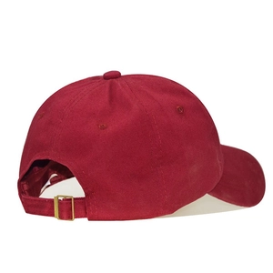 Detail of adjustable metal buckle and cotton strap on burgundy baseball cap