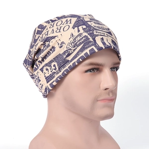 Detailed side view of beige slouchy beanie featuring a blue vintage newspaper print design