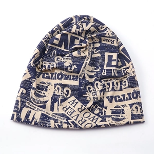 Detail of soft knit beanie featuring vintage newspaper print in blue and beige tones