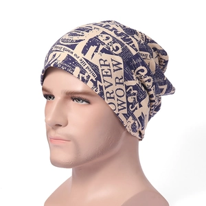 Detail of beige beanie with navy blue newspaper print on soft knit fabric