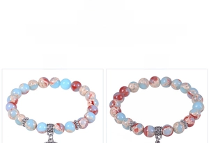 Detail of beaded snakeskin stone bracelets with Tree of Life and Hand of Fatima charms