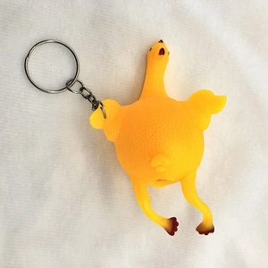 Detail of creative screaming chicken keychain made of textured yellow rubber with metal ring