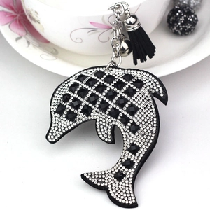 Detail of dolphin keychain with sparkling rhinestones, black tassel, and metal bell charm