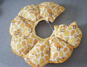 Detail of sunflower dog cone with giraffe print, featuring snap buttons and drawstring